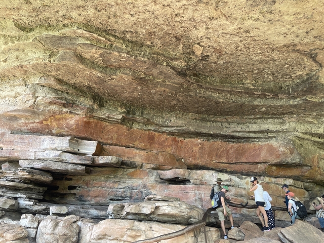 Rock formations with people exploring a cave.