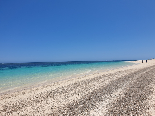 Pristine white sand beach with turquoise waters.