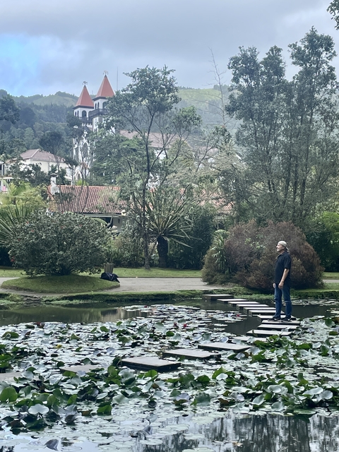      A person standing on stepping stones in a park setting.
  
