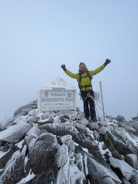 A climber celebrating on a snowy peak.