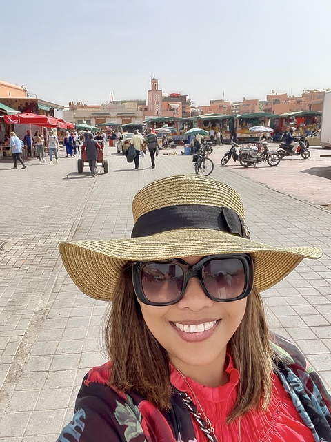 A woman wearing a hat in a busy street.