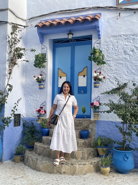 A woman in front of a blue and white door.