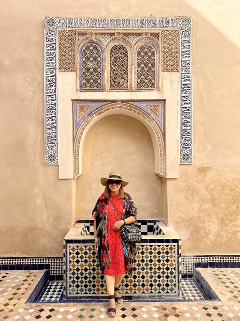 A woman posing in front of a traditional arch.