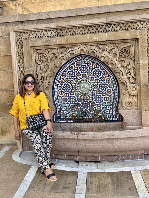       A woman in front of a decorative fountain.
  
