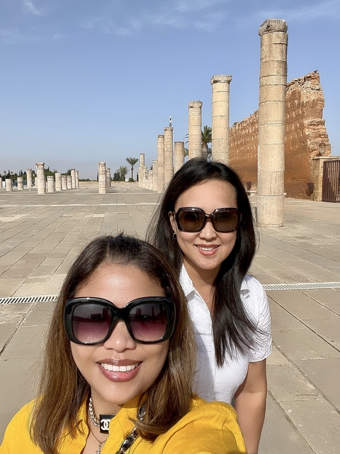 Women posing among ancient columns.