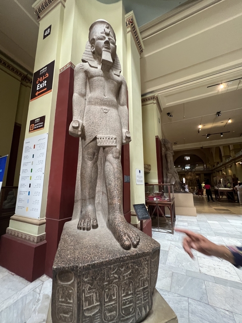       Statue inside a museum setting with informative signs.
  
