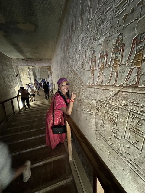       Person admiring hieroglyphics on a wall inside a temple.
  