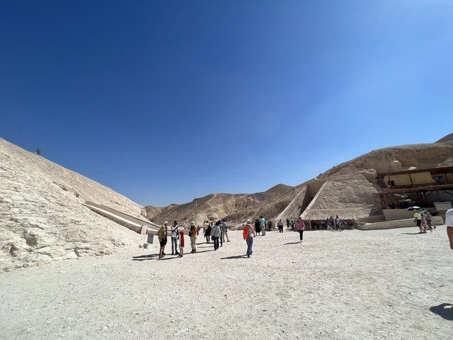       Tourists walking among hills and ancient structures.
  