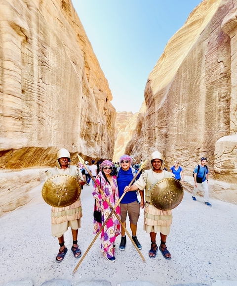       Couple posing with actors in ancient warrior costumes.
  