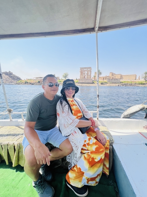 Two people enjoying a boat ride with a temple in the background.