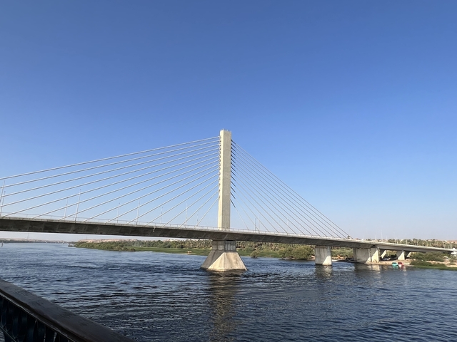       Cable-stayed bridge over a river with clear blue sky.
  