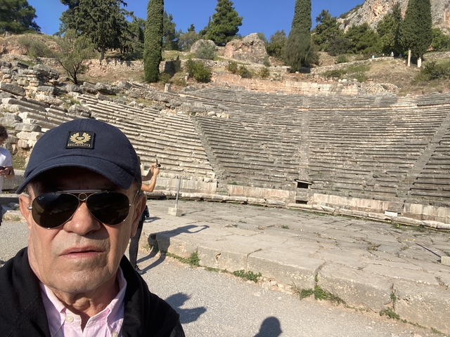       A person in front of an ancient amphitheater.
  