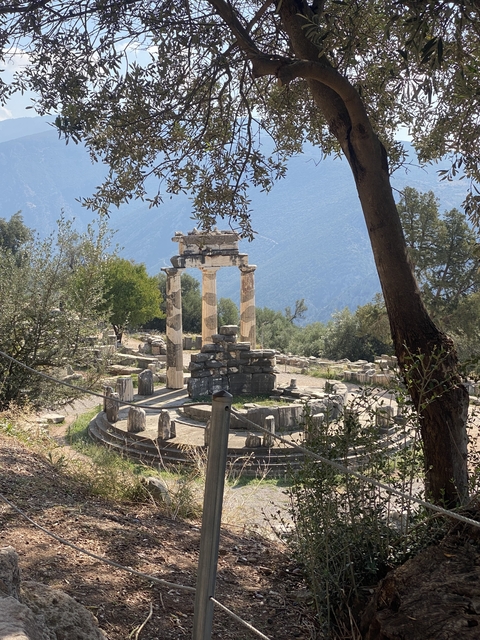       Ruins of a Greek temple with mountains in the background.
  