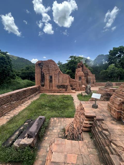 Ancient brick temple ruins surrounded by greenery.