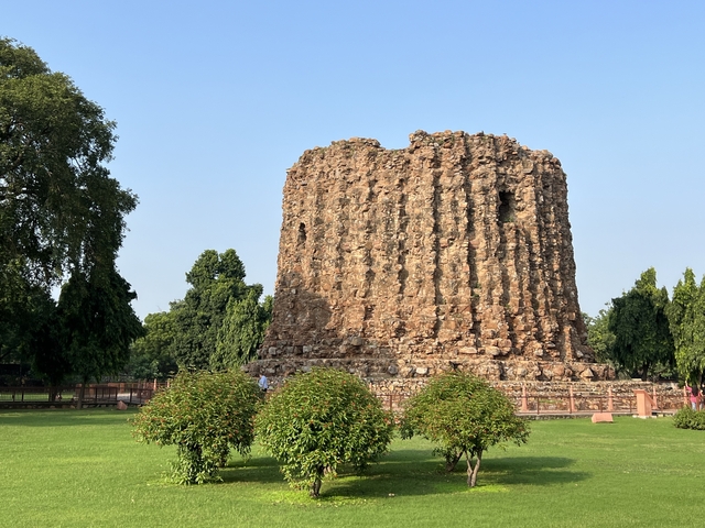 Ancient stone tower structure with surrounding greenery.