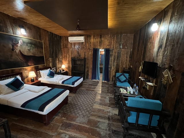 Rustic hotel room with wooden decor and twin beds.