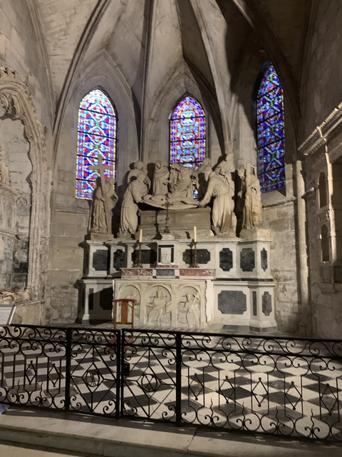 Interior of a church with statues and stained glass.