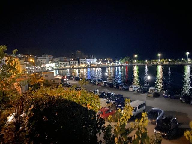 Nighttime waterfront with illuminated buildings.
