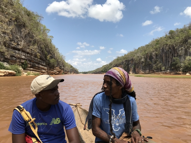 People discussing in a boat along a river.