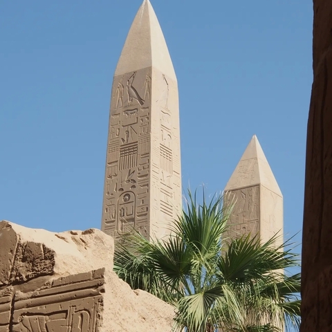 Two ancient obelisks under a clear sky.