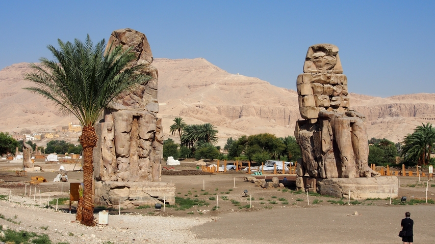 Ancient statues in a desert landscape.