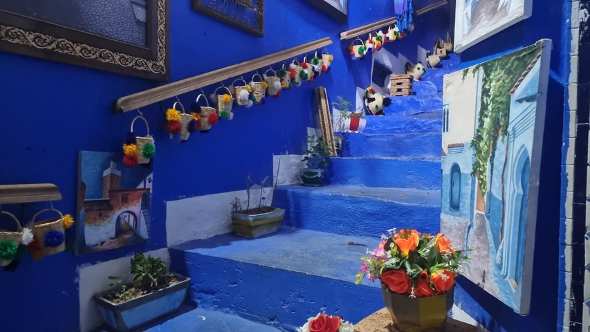 Blue-painted staircase with colorful decorations and flower pots.