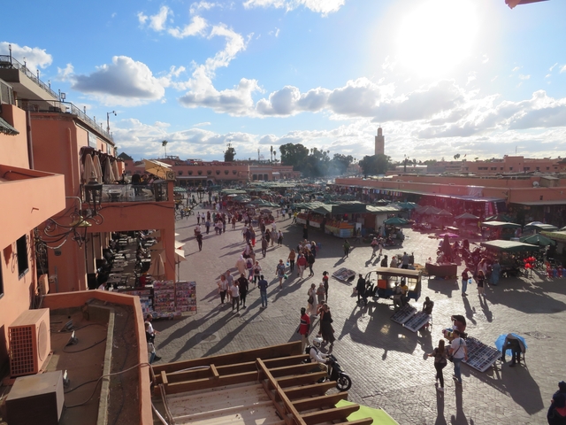 Street market in a busy square with people and vendor stalls.