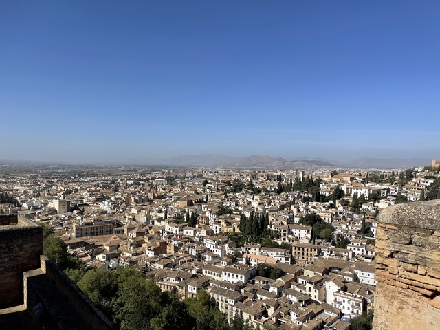 Panoramic view of a cityscape with mountains in the background.