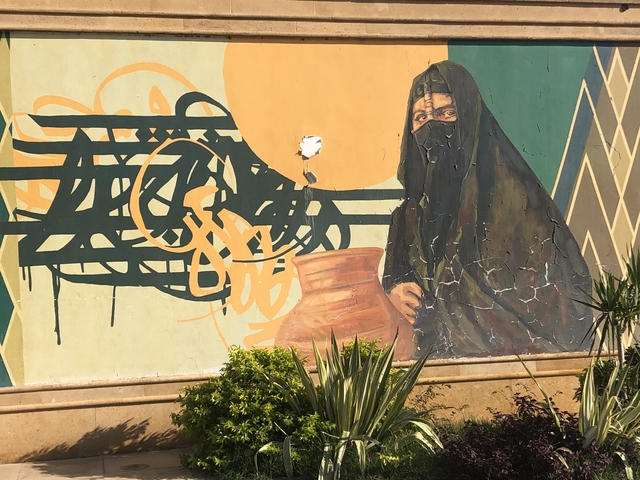       Wall mural featuring a woman and an urn.
  