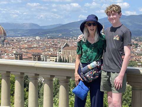 Two people standing on a viewing platform overlooking a cityscape.