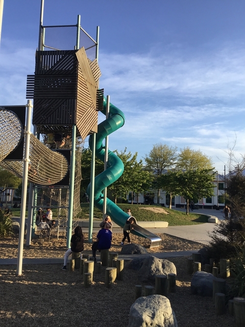       A children's playground with a large green slide.
  