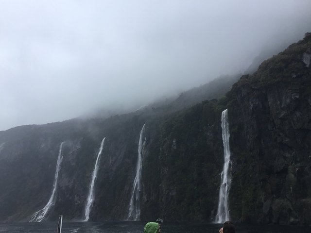      Tall waterfalls cascading down cliffs on a misty day.
  