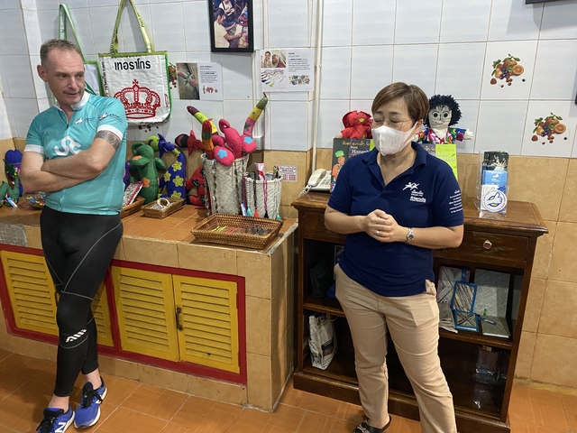       Two people in an indoor setting with products on shelves.
  