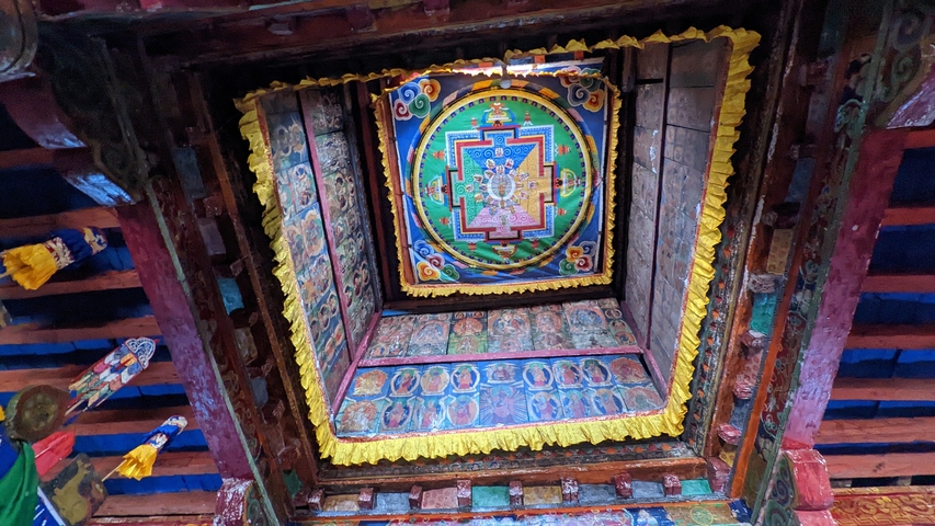 Colorful mandala artwork on a ceiling inside a building.