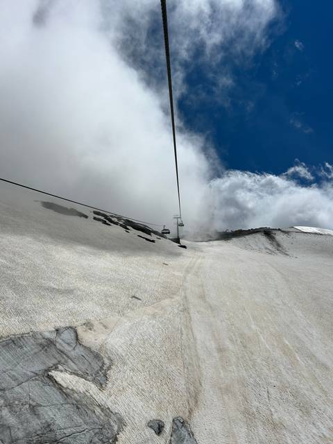 Ropeway against a dramatic mountain and sky backdrop.