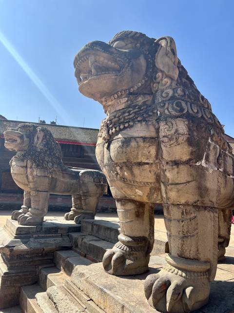       Ancient stone lion statues in a historic courtyard.
  