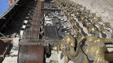       Artistic metal and wood carvings in a temple setting.
  