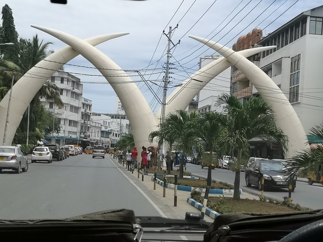       A street in Mombasa with large tusk-shaped arches.
  