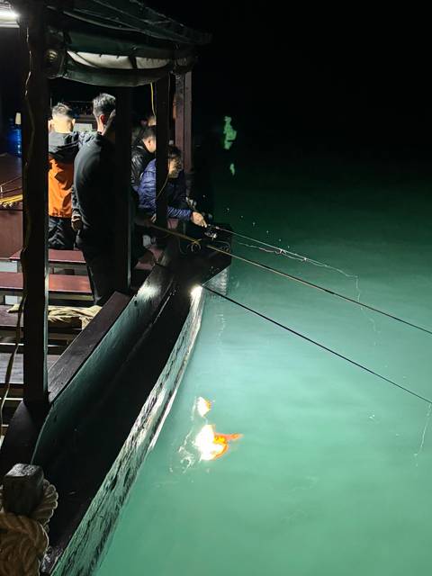       Night fishing activity on a boat.
  