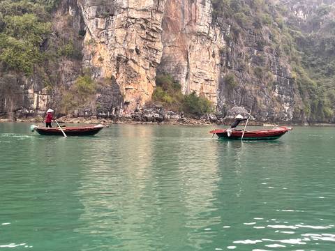 Limestone formations and boats on water.