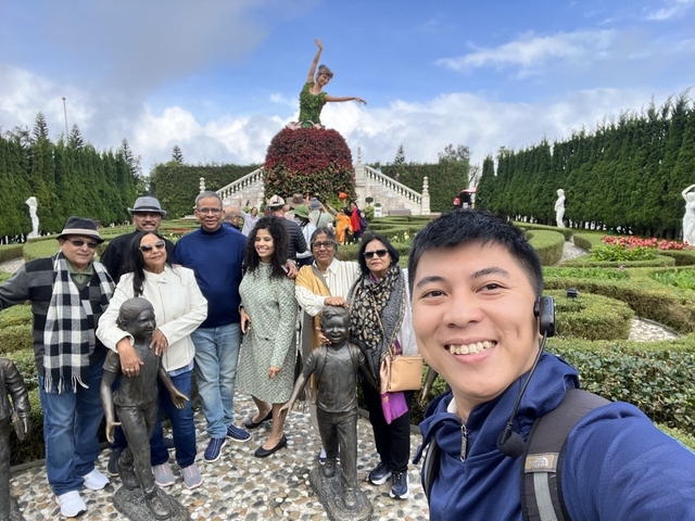 Group of people in a garden with statues.
