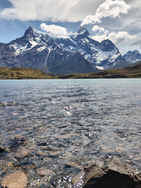       Close view of a clear lake with mountains in the background.
  