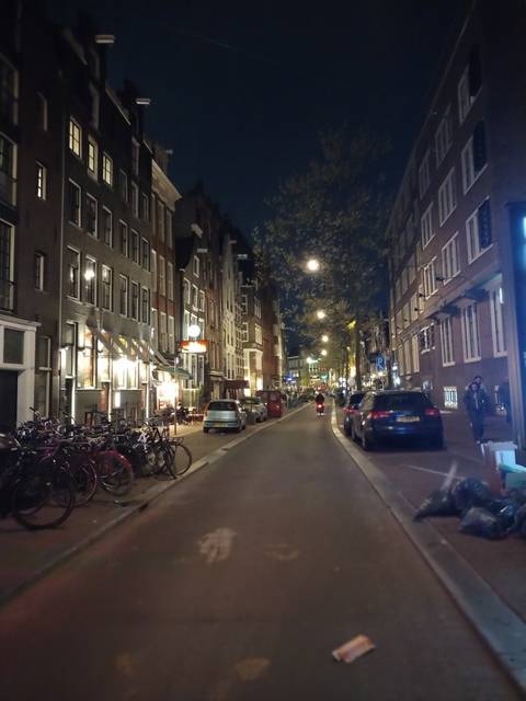       Nighttime view of a street with lights and bicycles.
  