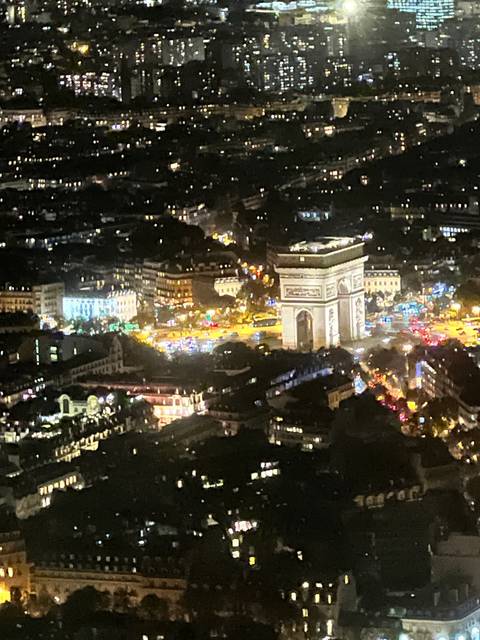       Rotated view of an illuminated arch in a city at night.
  
