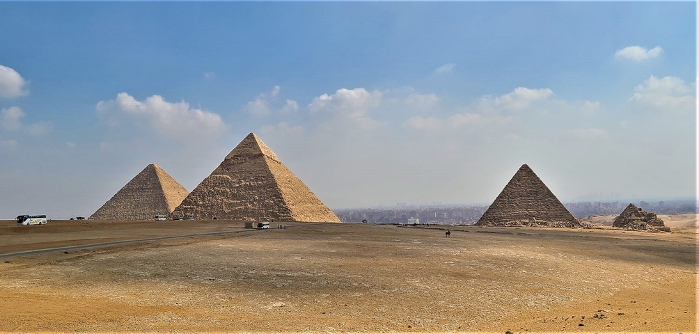       Panoramic view of the Pyramids of Giza under clear sky.
  