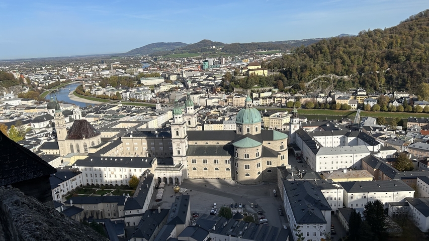       Aerial view of Salzburg with river and historic buildings.
  