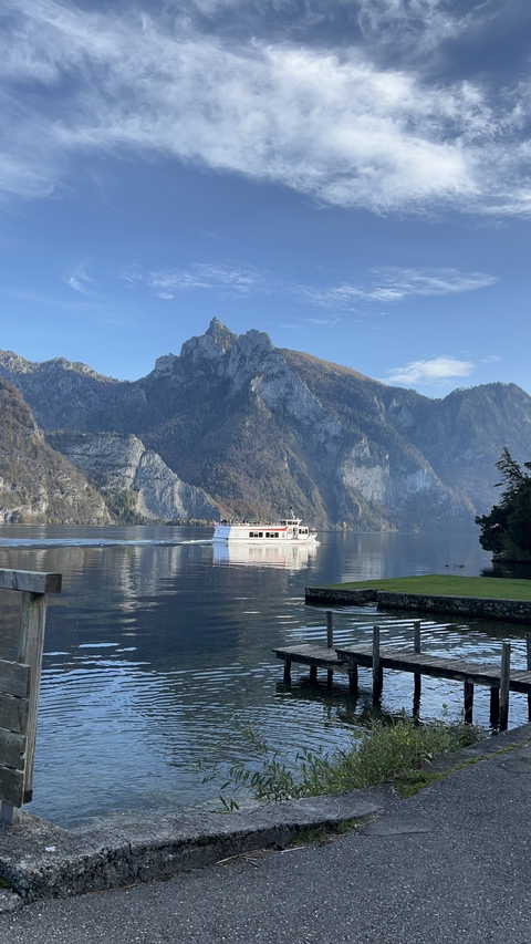       Boat cruising on a lake surrounded by mountains.
  