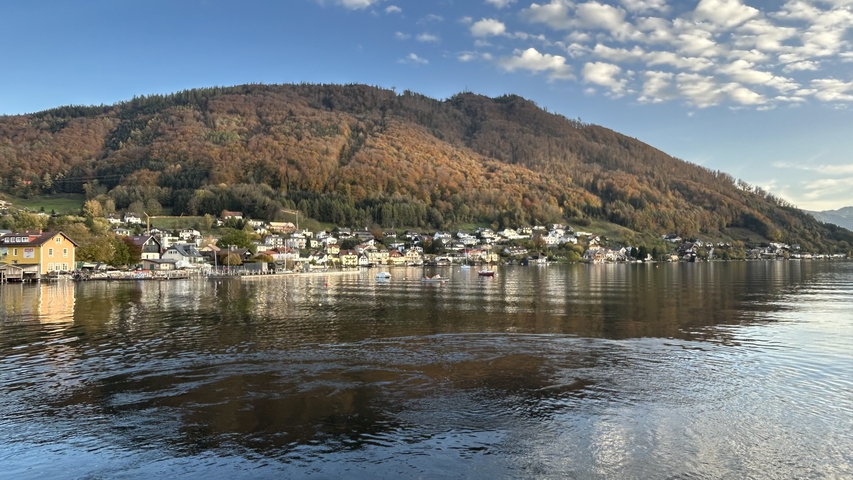       Lakeside view with autumn foliage and mountains.
  
