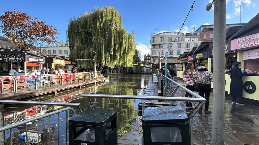 Busy canal with shops and people.