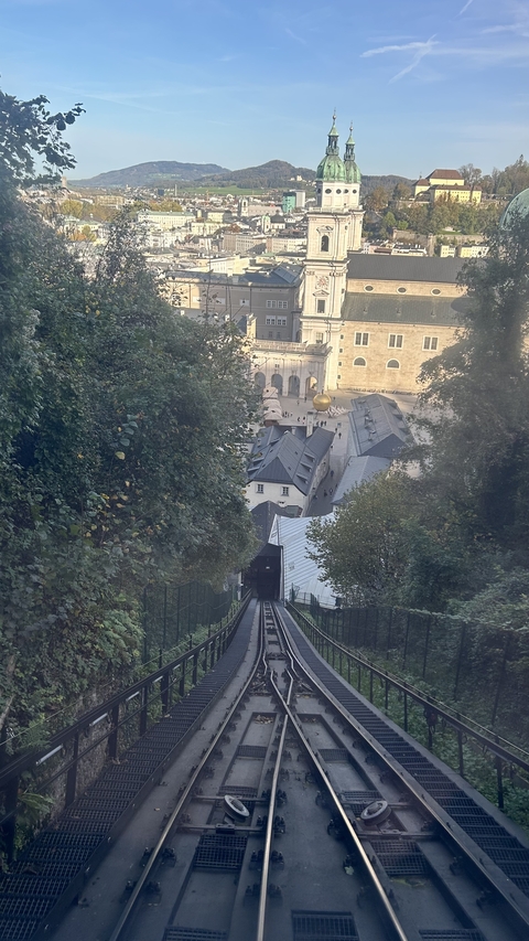       View of a hill with a historic building in the background.
  